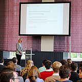 Eine Person hält eine Präsentation vor einem Publikum